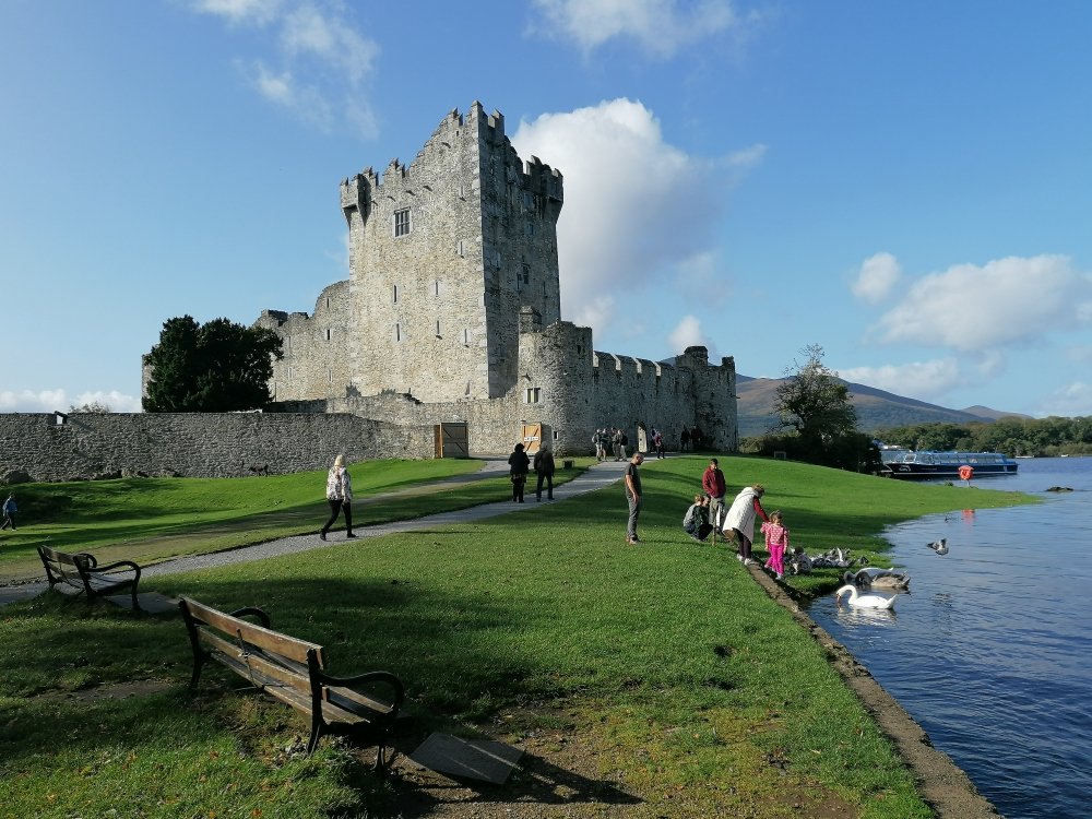 castle with people walking beside it 